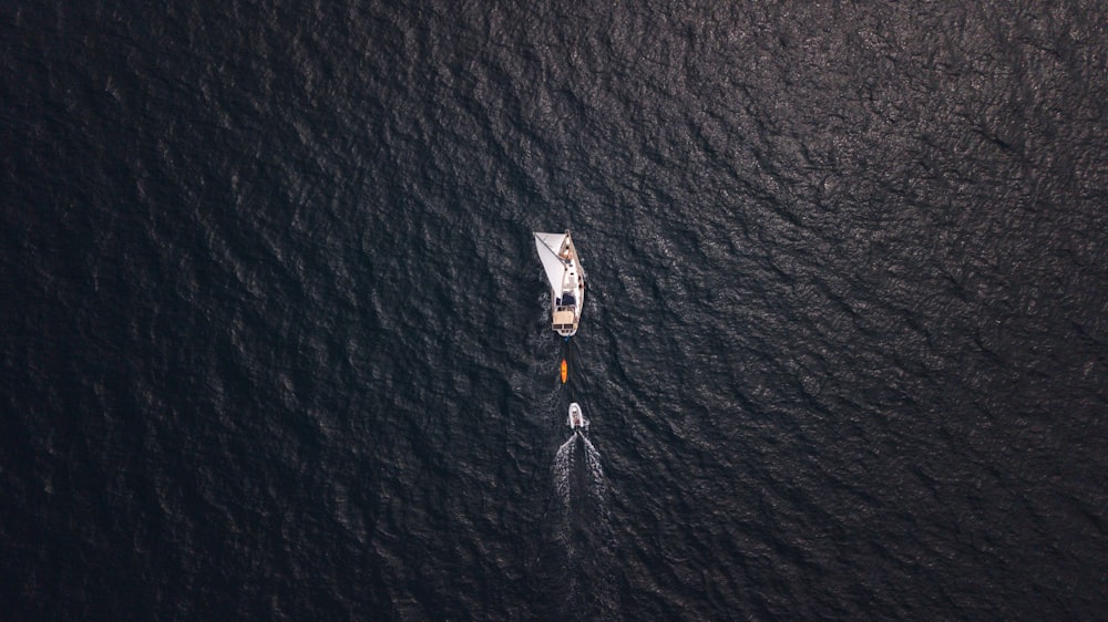 aerial view of person in white shirt and black pants on body of water during daytime