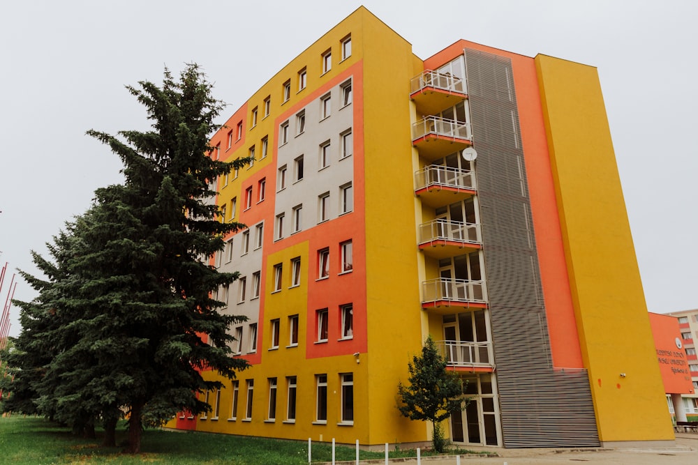 Edificio in cemento arancione vicino agli alberi verdi durante il giorno