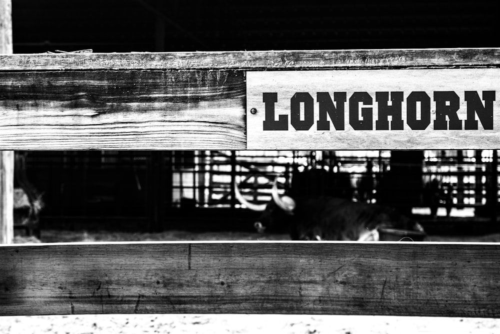 grayscale photo of wooden fence with no smoking sign