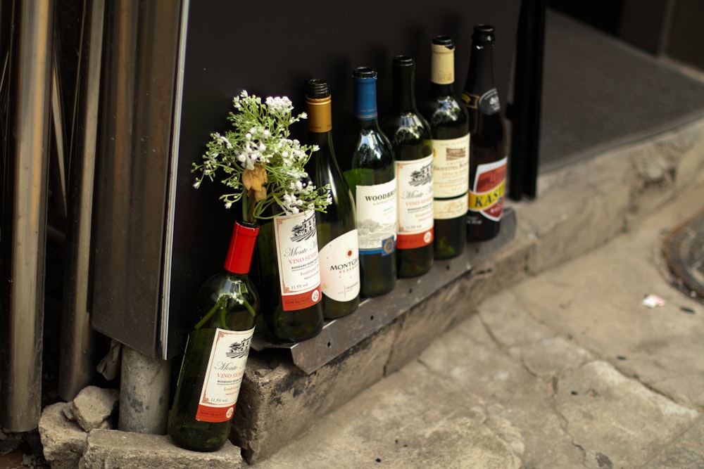 green glass bottles on gray concrete floor