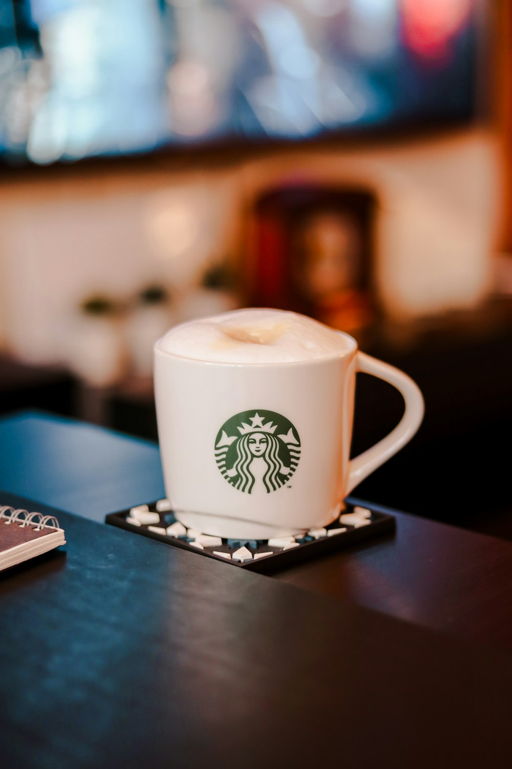 white and green starbucks ceramic mug on black wooden table