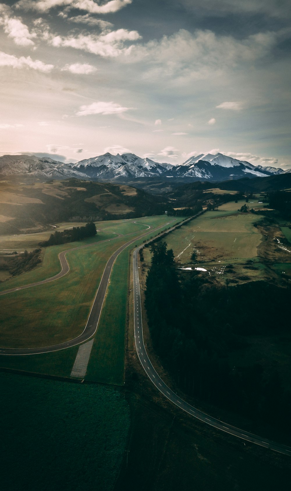 green grass field near snow covered mountain during daytime