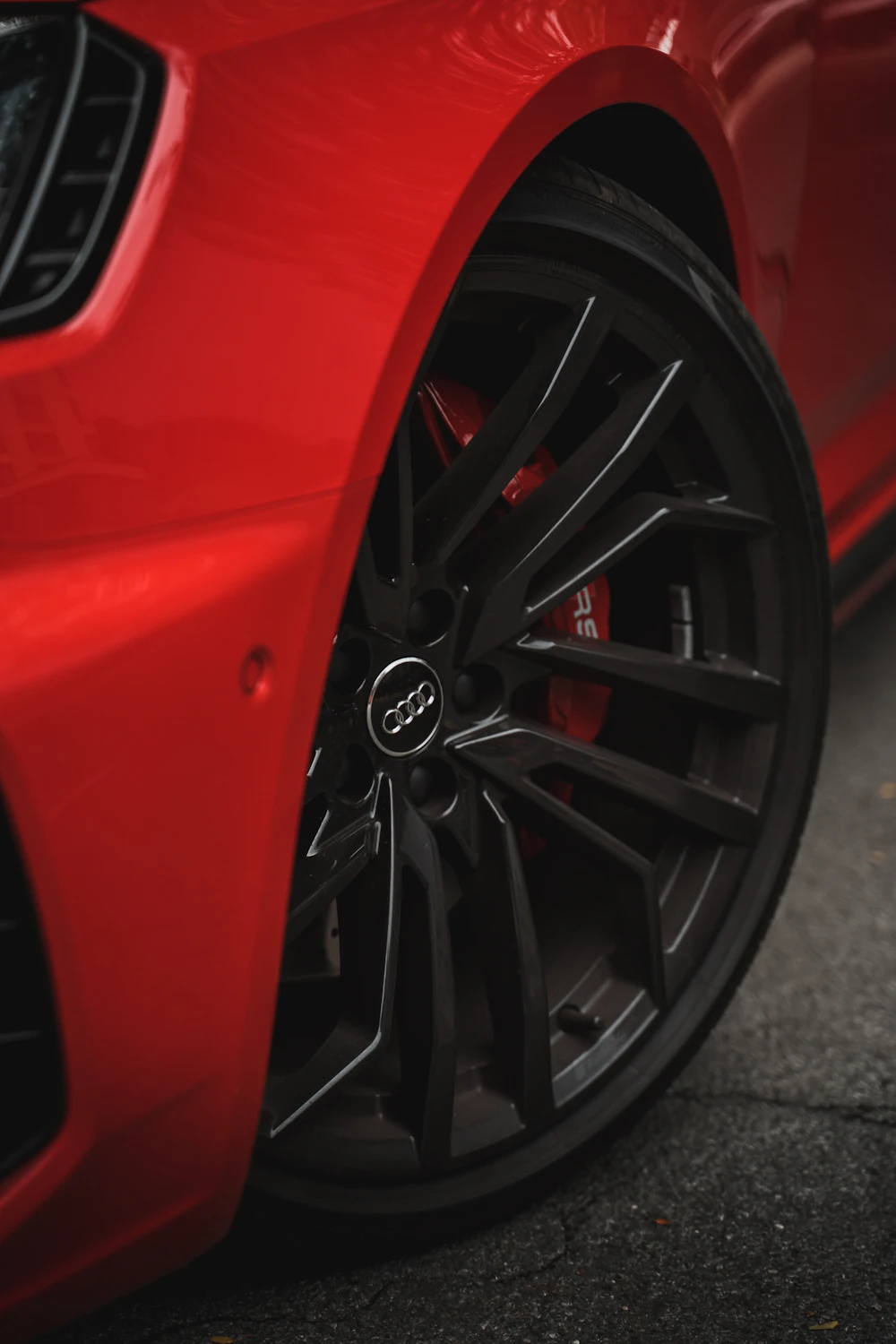 Gloss black sport alloy wheel fitted to a red sports car