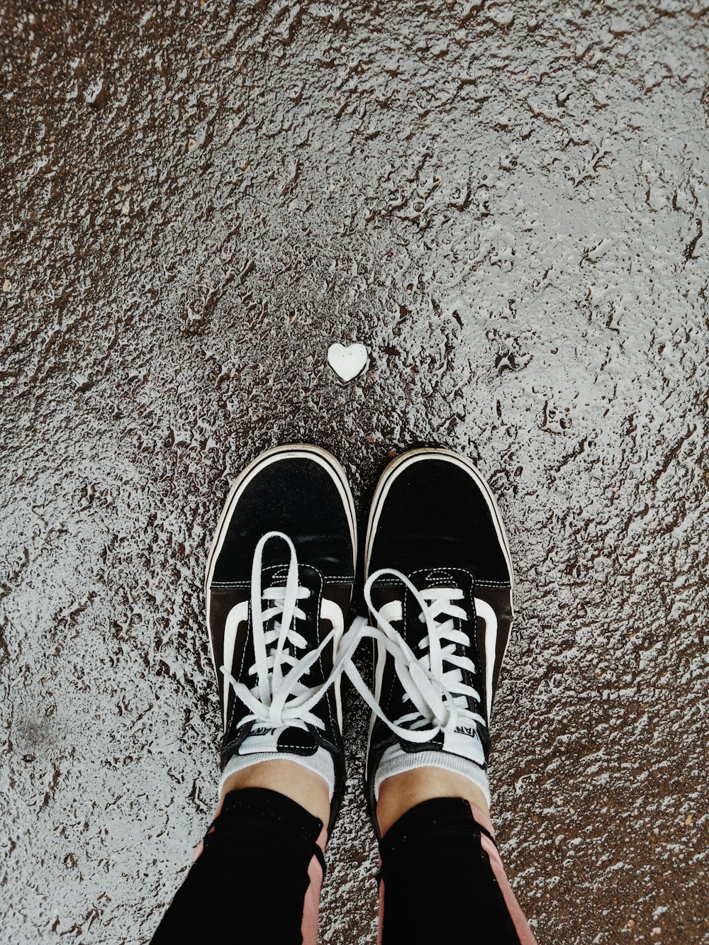 person wearing black and white sneakers