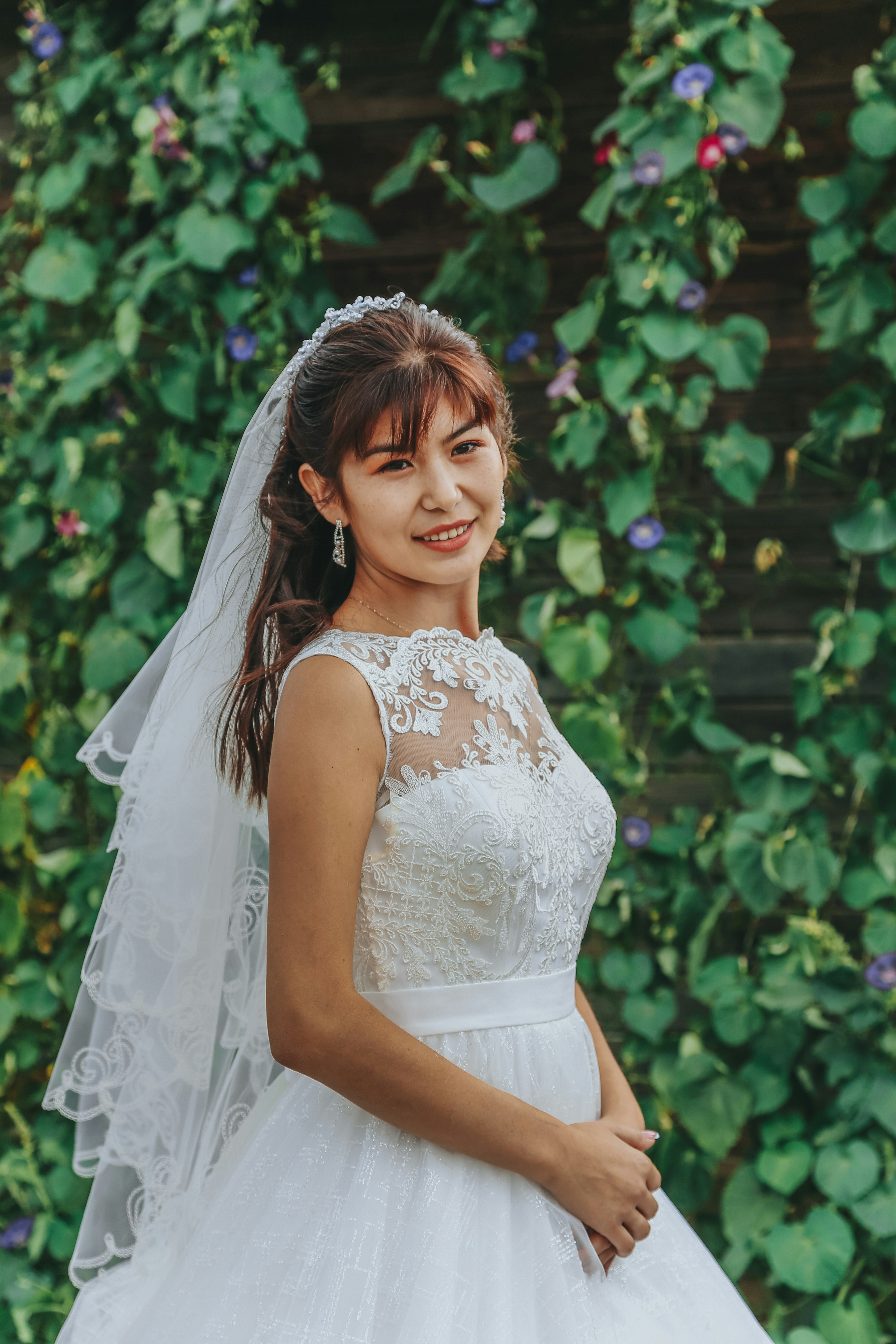woman in white floral dress standing near green plants