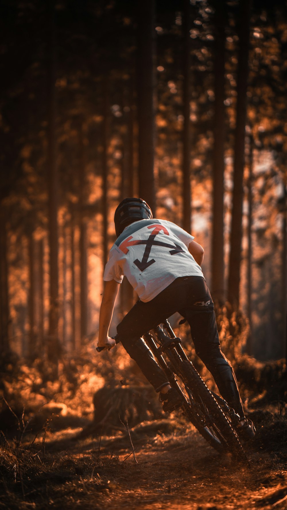 man in white and black t-shirt and black pants standing on forest during daytime