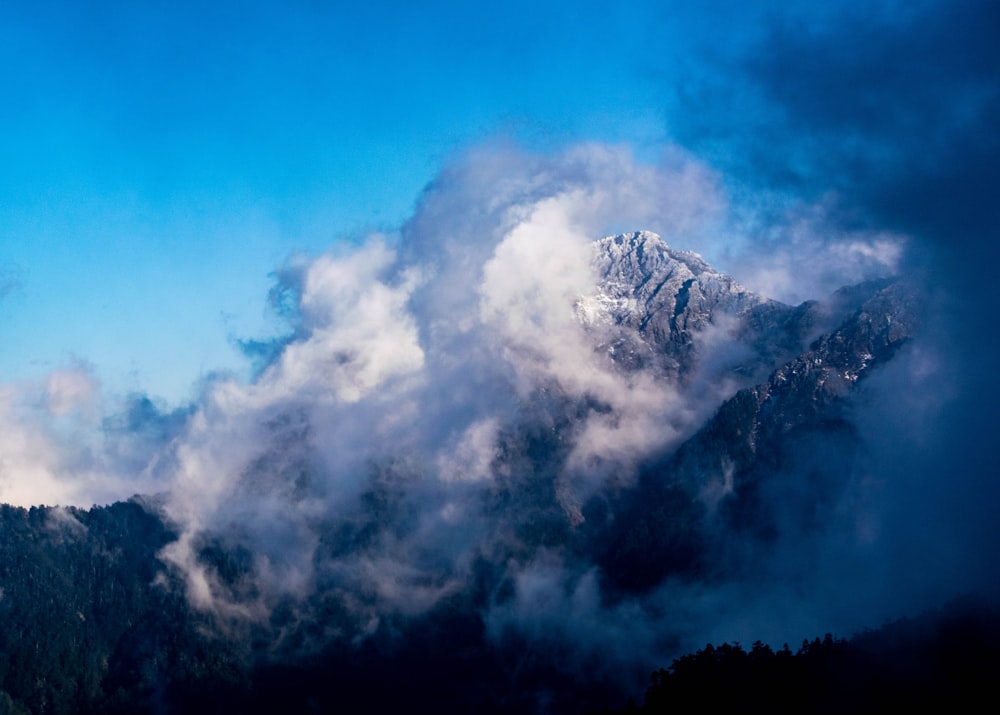 white clouds over snow covered mountain