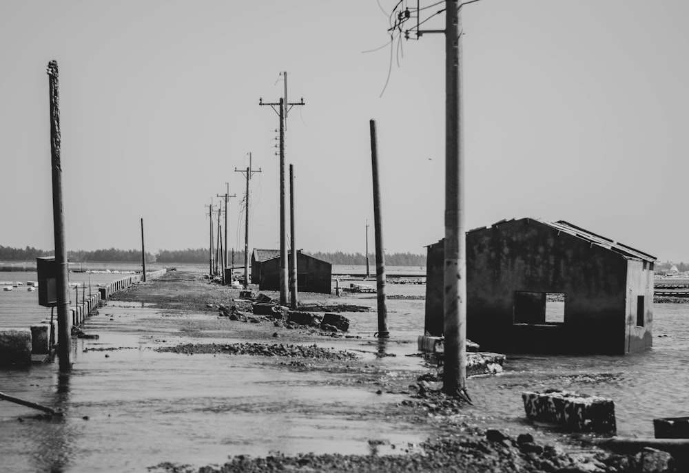 grayscale photo of electric posts on snow covered ground