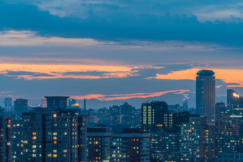 city skyline under orange and blue cloudy sky during sunset