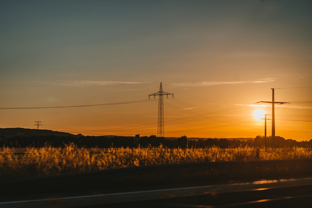 Silueta de la torre eléctrica durante la puesta del sol