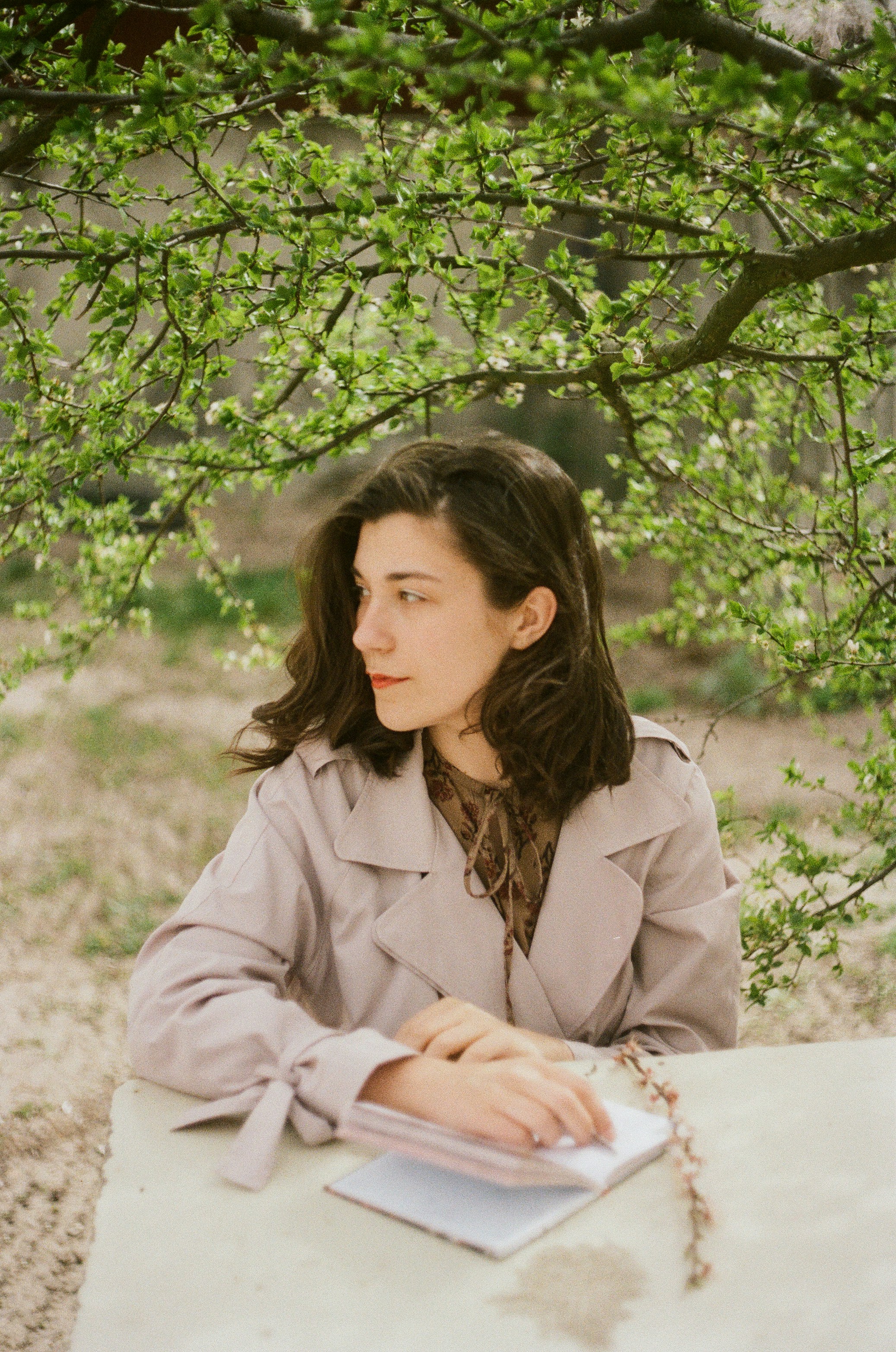 woman in white coat sitting on white bench