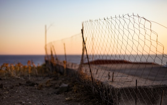 black metal fence near body of water during daytime in Lesvos Greece