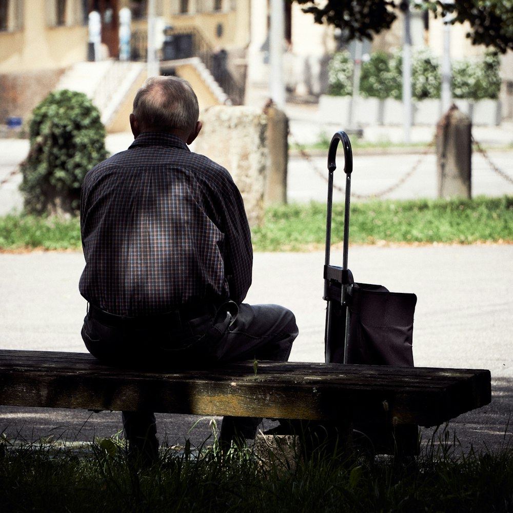 man in black jacket sitting on bench
