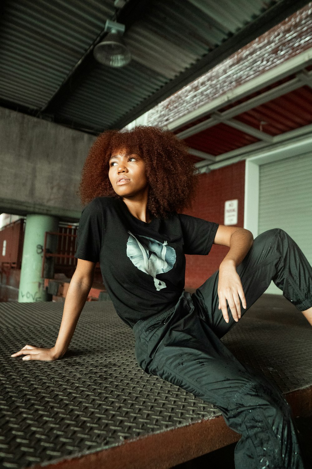 woman in black t-shirt and black pants sitting on the floor