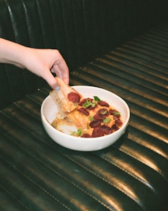 A hand holding a water bottle showcasing detailed hand-painted pizza artwork.