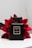 A sleek black perfume bottle labeled Coco Noir Chanel Paris is positioned against a backdrop of vibrant red flowers. The bottle's simplistic design and gold accents exude luxury and elegance. The contrast between the dark bottle and the bright flowers creates a striking visual appeal.