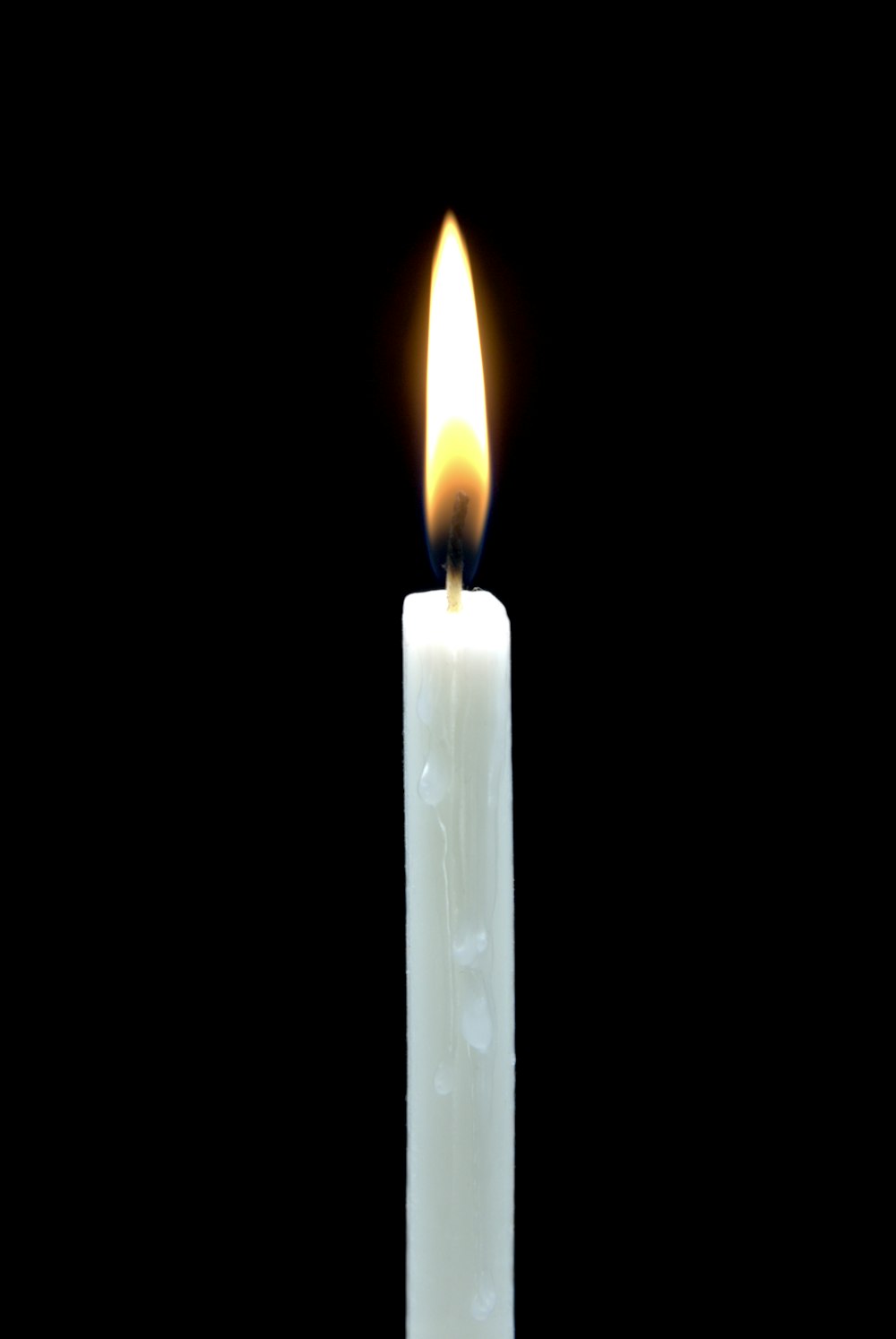 white lighted candle in dark room