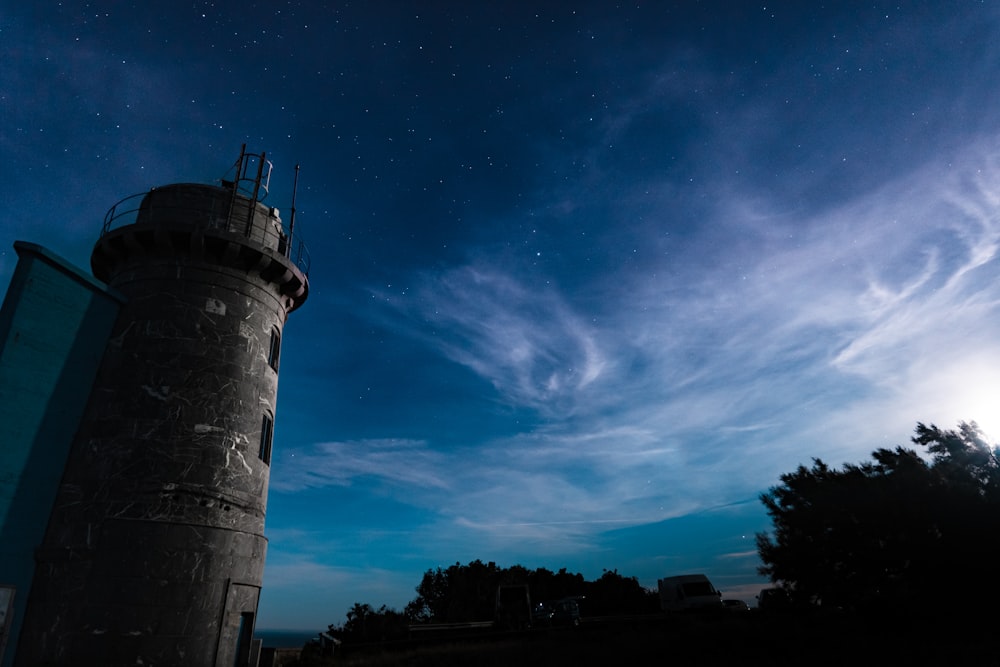 torre de concreto marrom sob o céu azul e nuvens brancas durante o dia