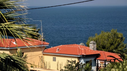 white and brown concrete building beside blue sea during daytime in Nikiti Greece