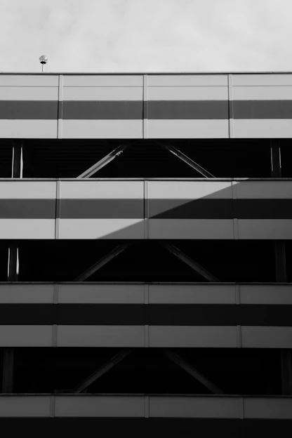 Sleek black and white photo of a modern parking garage with clean lines and minimalistic design.