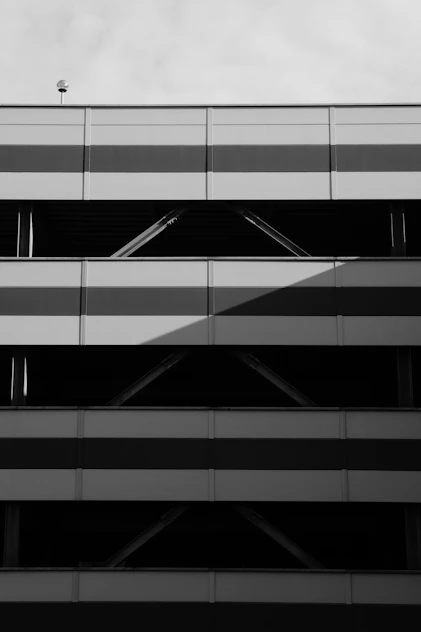 Sleek black and white photo of a modern parking garage with clean lines and minimalistic design.