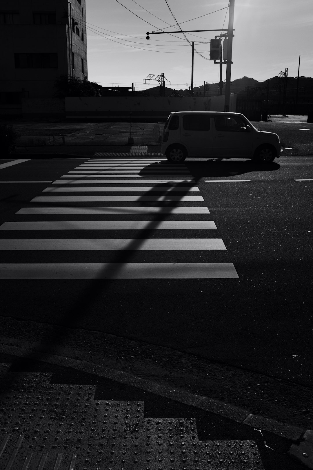 grayscale photo of a car on a pedestrian lane