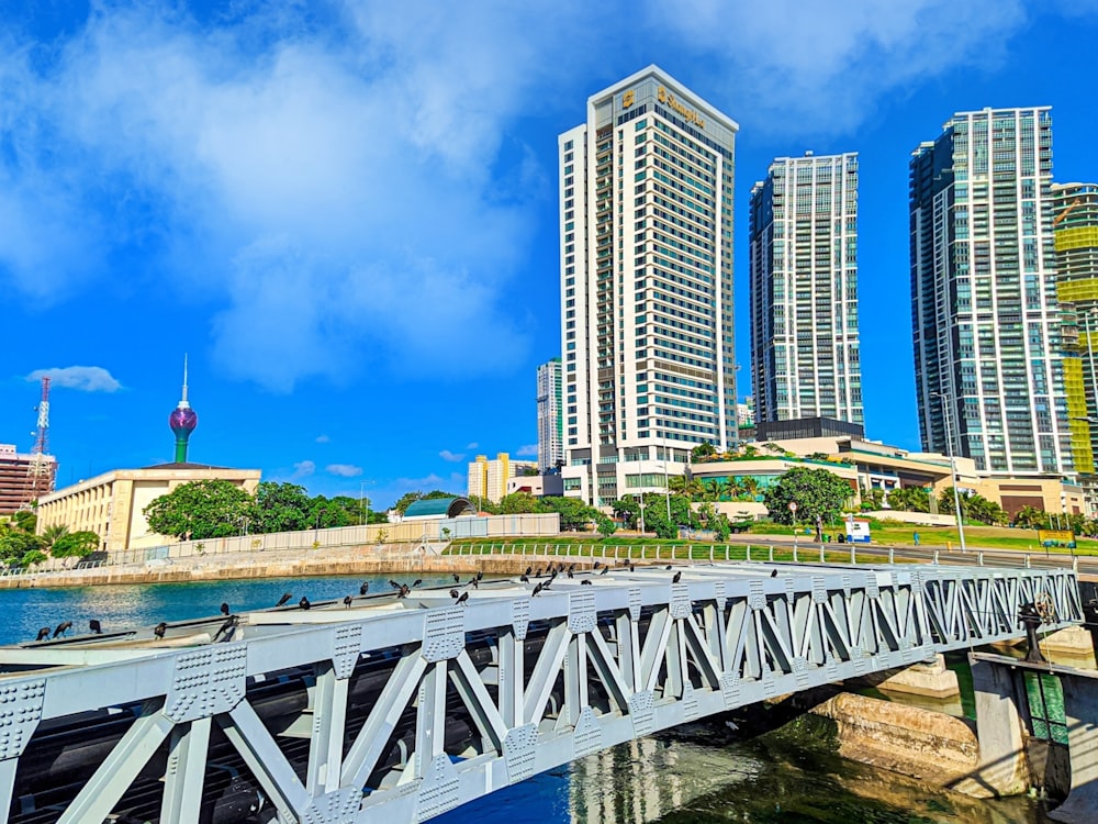 ponte branca sobre o rio perto de edifícios da cidade durante o dia