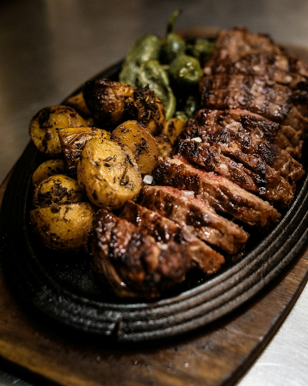 黒い陶板に盛られた肉のグリル