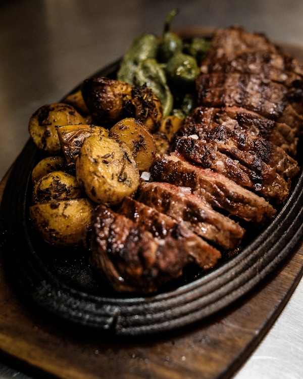 Grilled meat on black ceramic plate