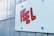 A close-up of a textured wall featuring a stylized word 'FEEL' painted or pasted in bold red letters with a black outline on a light blue background.