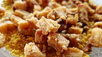 Close-up of crispy golden pork cracklings on rustic wooden board