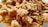 Close-up of crispy fried pork rinds with a golden brown color, displaying a crunchy texture. The pieces are irregularly shaped and piled together, highlighting the savory crust.