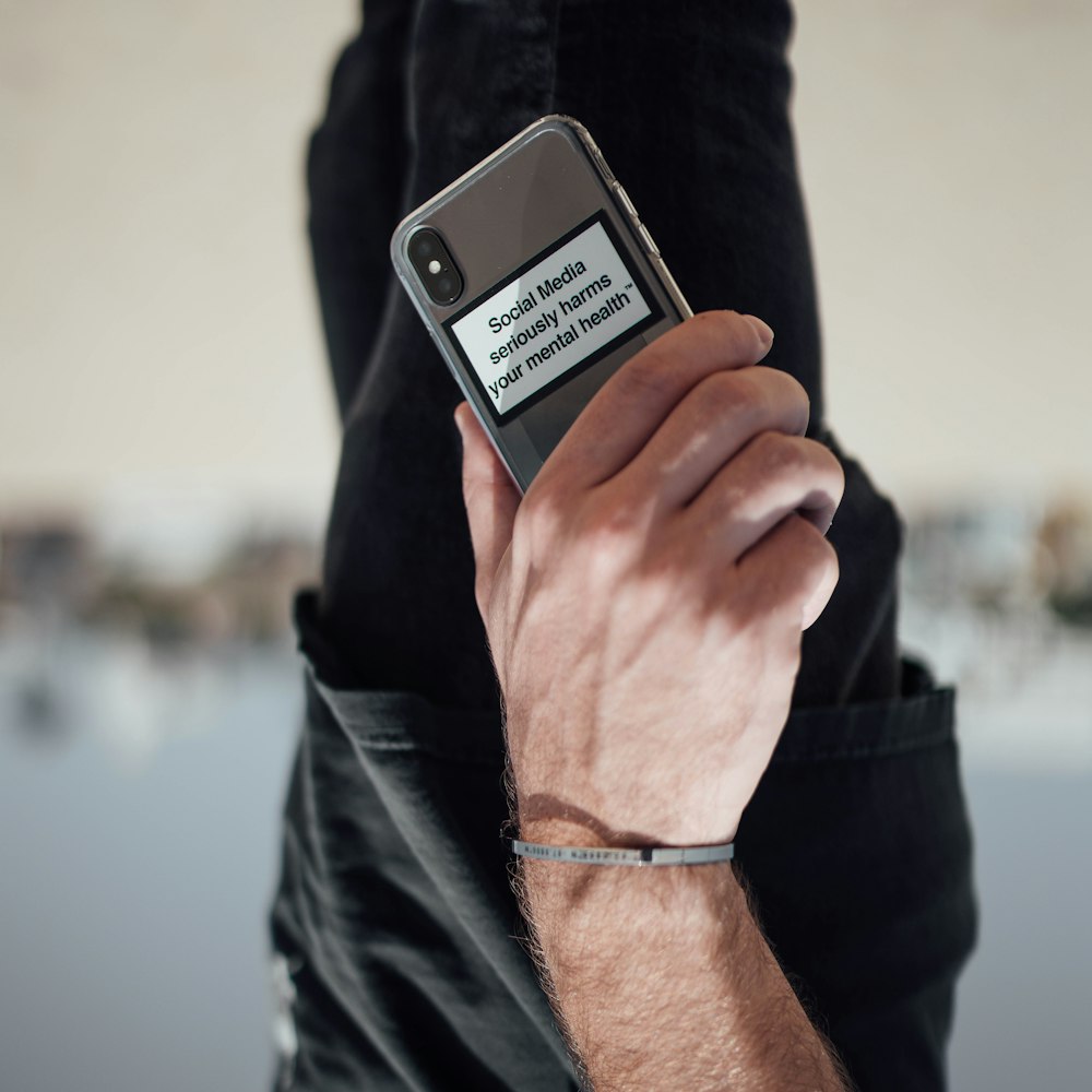 person holding black iphone 4