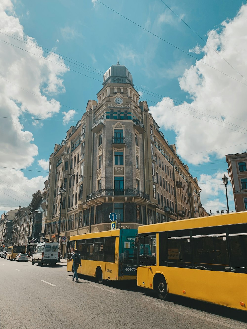 낮 동안 갈색 콘크리트 건물 근처 도로에 노란색 버스