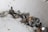 A collection of metallic bolts and screws scattered on a slightly dusty surface. The items vary in size and feature a mix of rust and shine, indicating some are older and worn while others are newer.