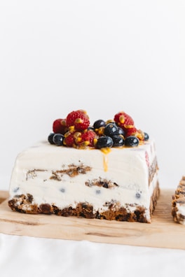 Slice of creamy pavê dessert topped with chocolate shavings and berries.