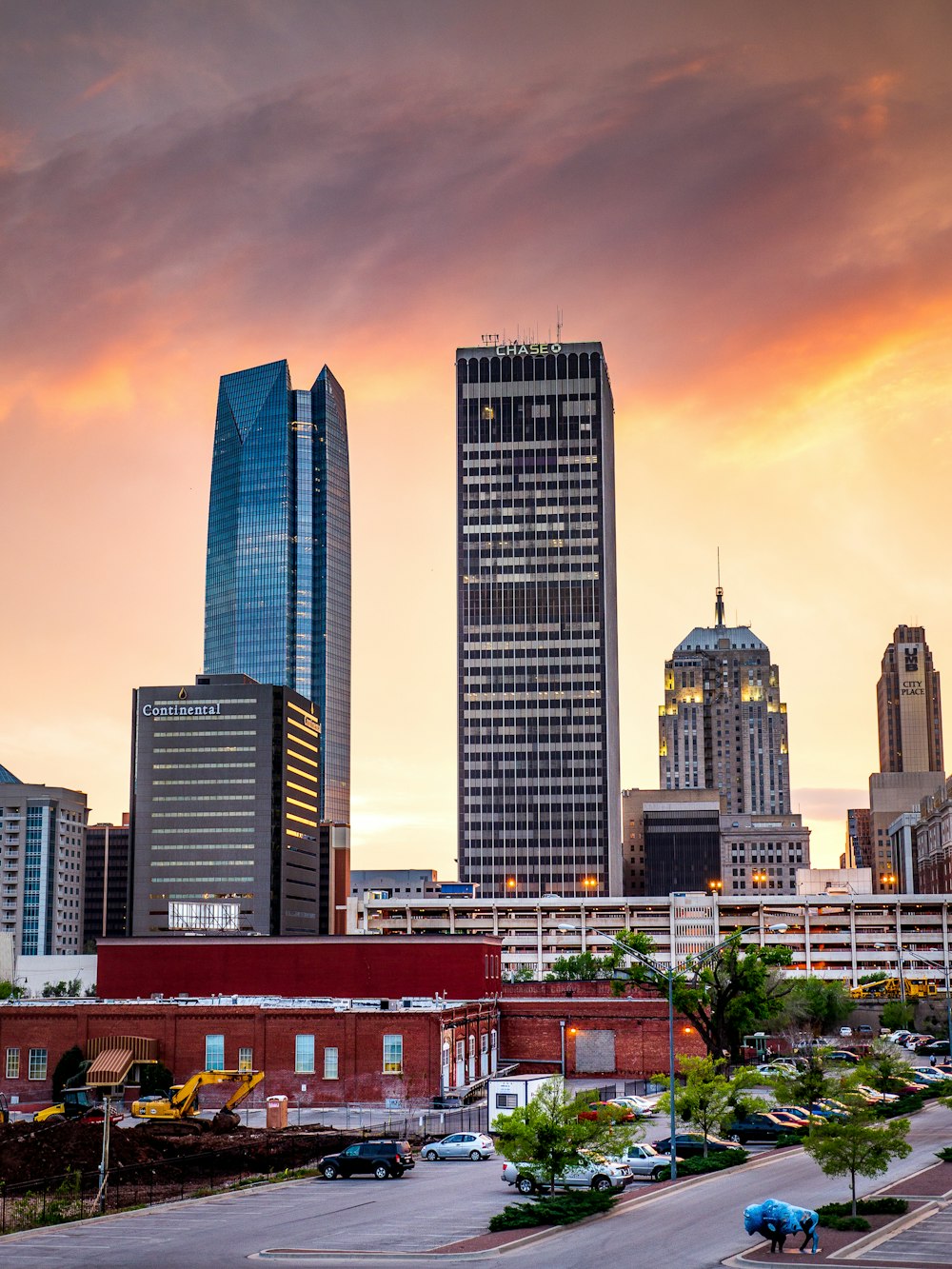 city skyline under orange and blue sky during sunset