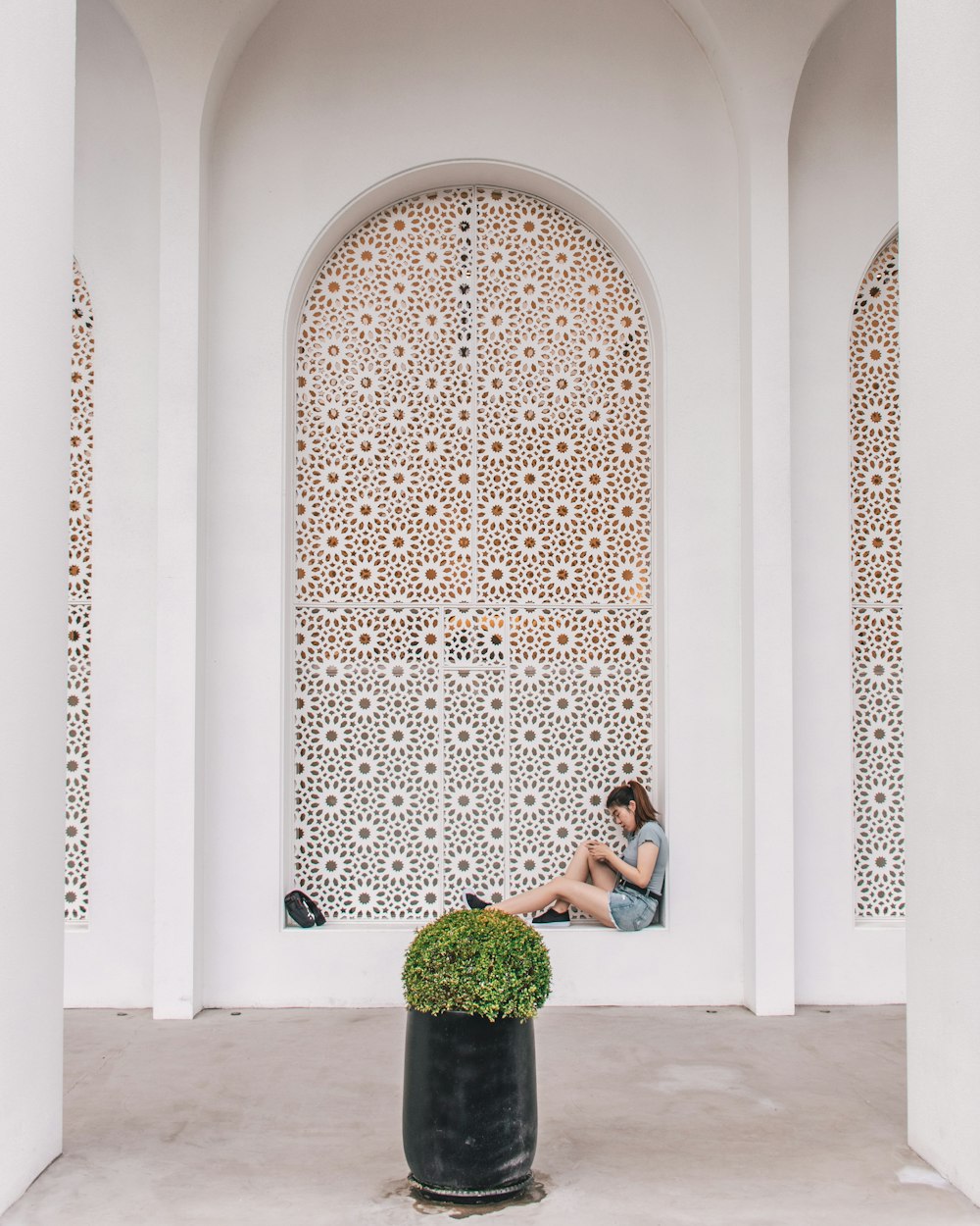 woman in black tank top sitting on white concrete bench