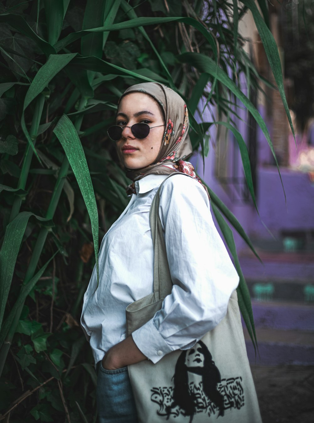 woman in white hijab standing near green plant