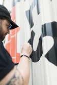 A detailed shot of vinyl lettering being carefully applied to a glass window.
