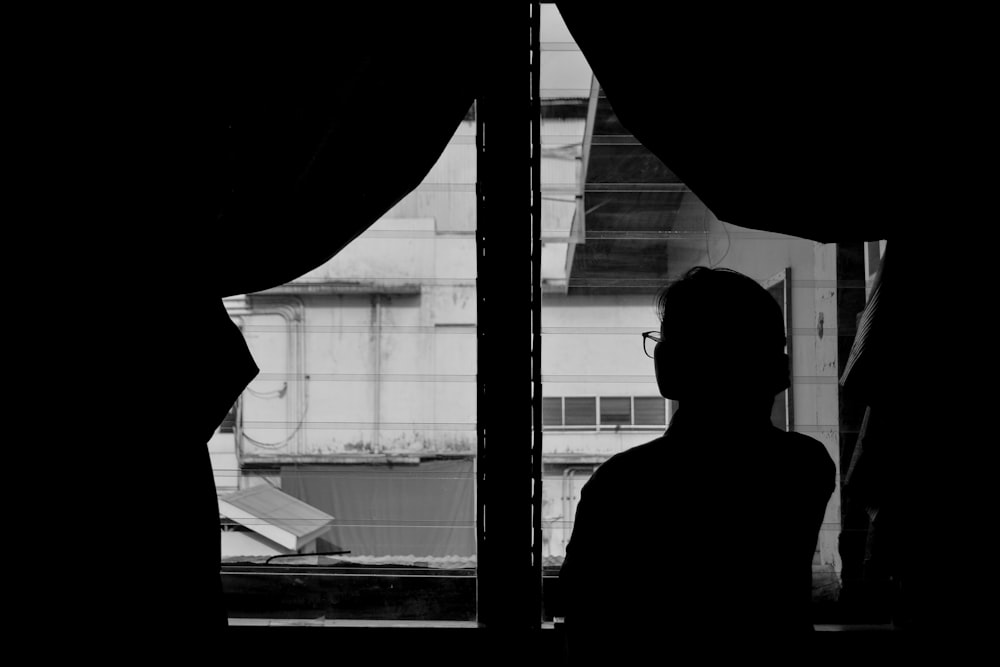 silhouette of woman standing near window