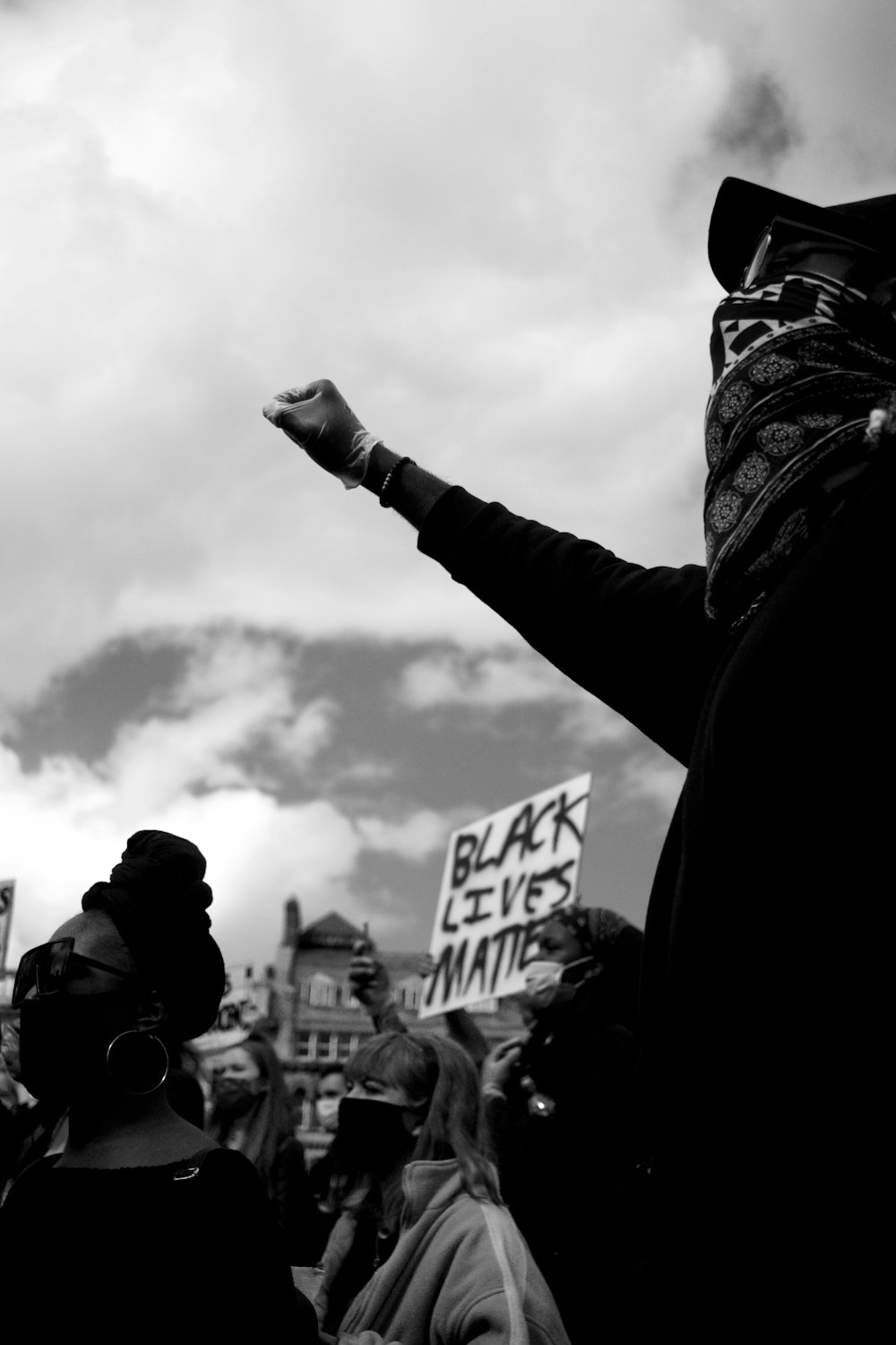 Foto en escala de grises de una persona sosteniendo un cartel