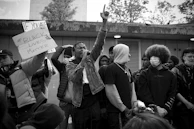 A group of diverse individuals wearing blacksess apparel, standing tall together in solidarity.