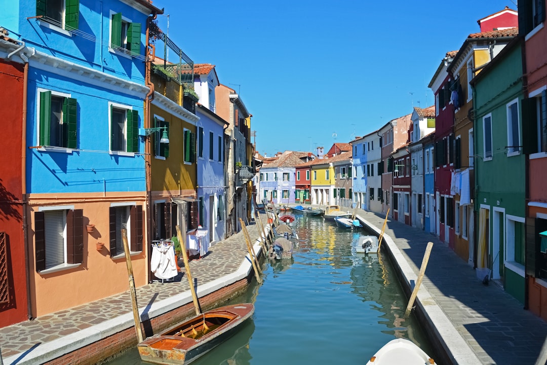 boat on river between houses during daytime