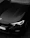 High-end black BMW with a flawless ceramic coating shining under soft golden light.