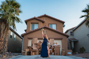 woman in black dress standing near brown concrete building during daytime