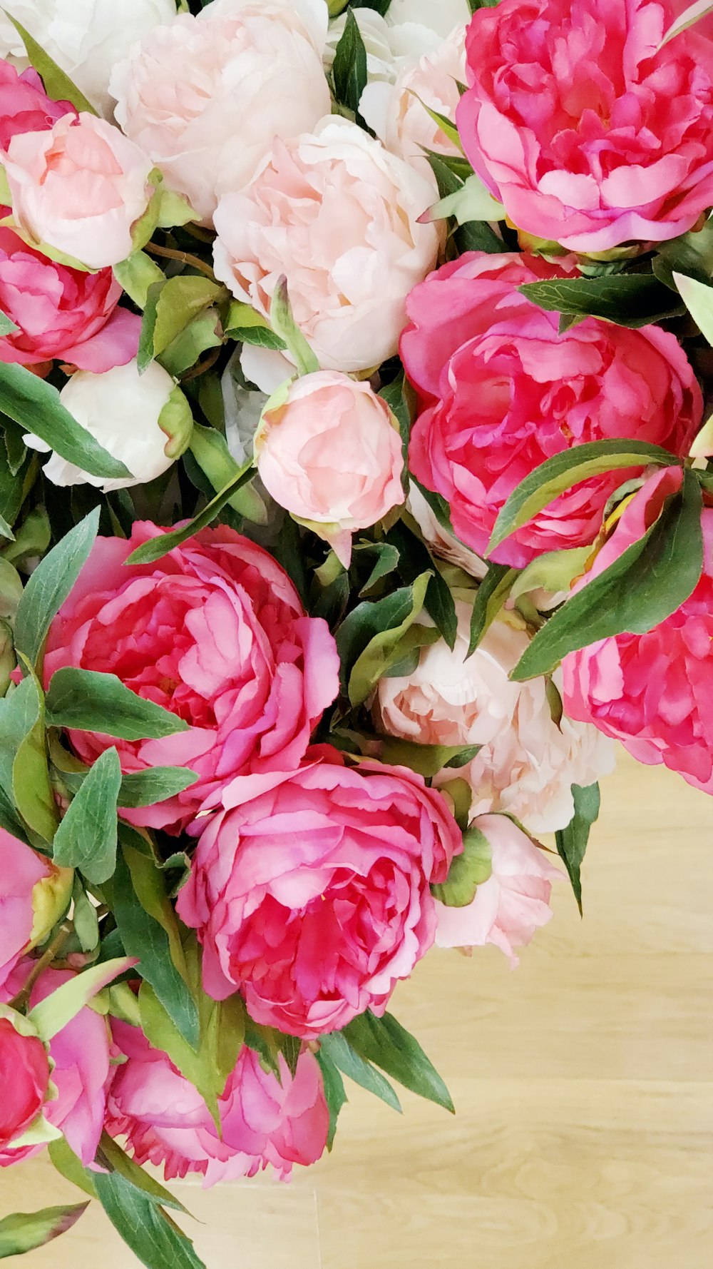 pink and white roses on brown wooden table