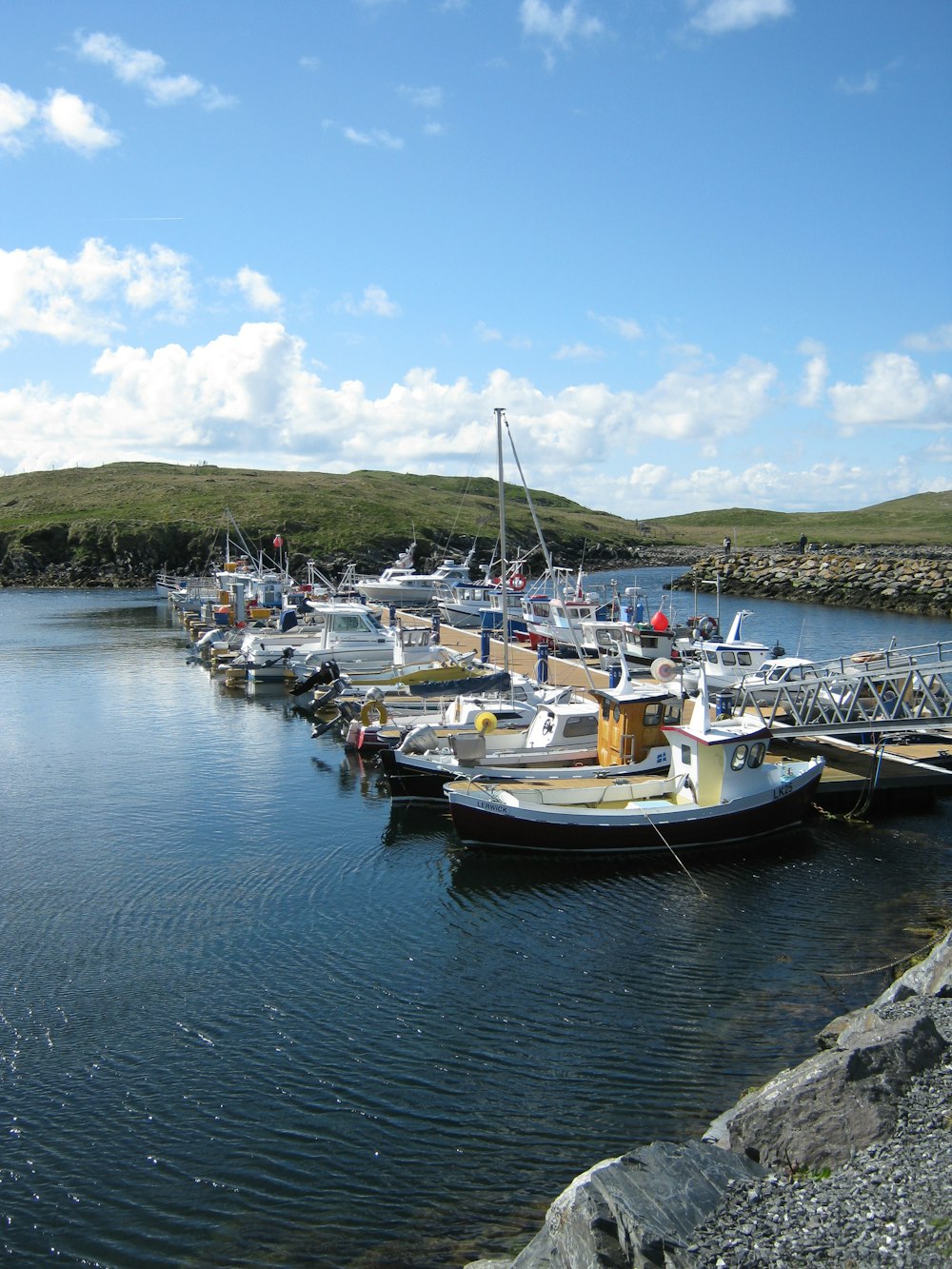 white and blue boats on body of water during daytime