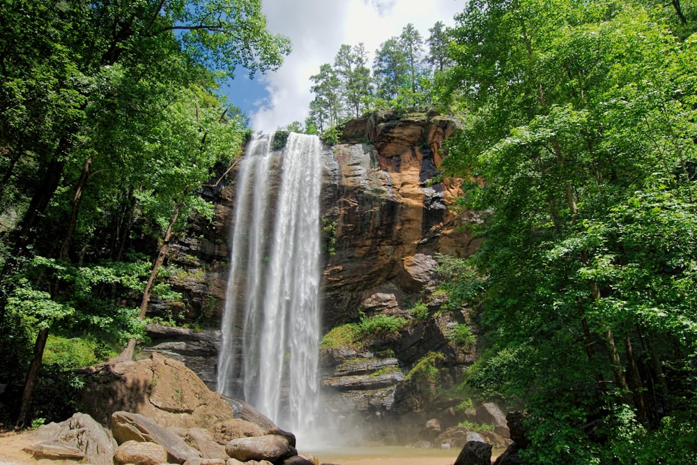 waterfalls on brown rocky mountain under blue sky during daytime