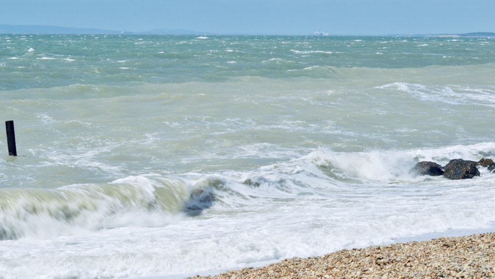 ocean waves crashing on shore during daytime